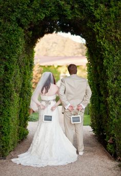 the bride and groom are walking through an archway