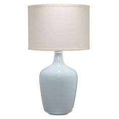 a light blue table lamp with a white shade on the top and bottom part of it