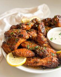 chicken wings with dipping sauce and lemon wedges