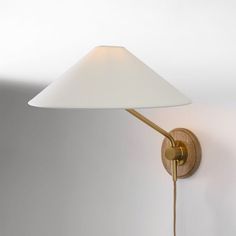 a wall lamp with a white shade on it's side and a wooden arm