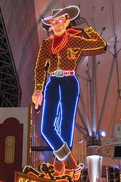 a large neon sign with a cowboy on it's head in the shape of a skateboarder