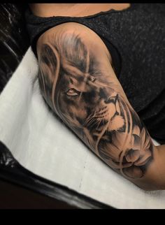 a man's arm with a lion and cross tattoo on the left side of his arm