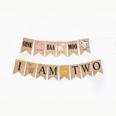 a banner that says i am two hanging from a string with animals on it and the words one baa moo, i am two