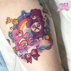 a woman's thigh with a bear and rainbow tattoo design on her left leg