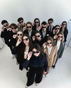 a group of people in suits and sunglasses posing for the camera