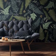 a living room scene with focus on the couch and wallpaper that looks like leaves