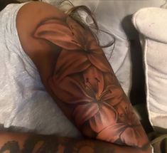 a woman laying on top of a bed covered in tattoos