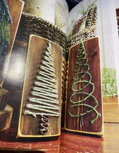 an open book with christmas tree decorations on the pages and pictures in it, sitting on a wooden table