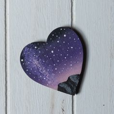 a purple heart with white stars on it sitting on top of a wooden table next to a wall