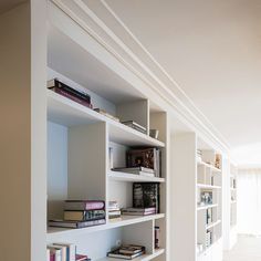 a white book shelf with many books on it