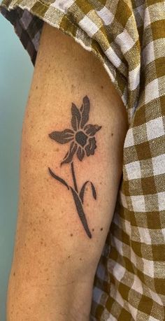 a woman's arm with a flower tattoo on the left side of her arm