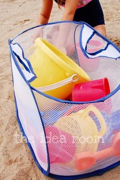 an image of a child's beach bag on the sand with toys in it