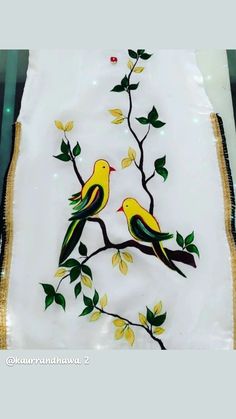 two birds sitting on a tree branch with yellow flowers and green leaves painted on it