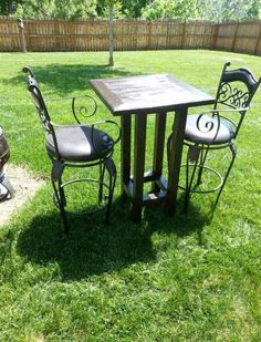 an outdoor table and chairs set up in the grass near a small fire hydrant