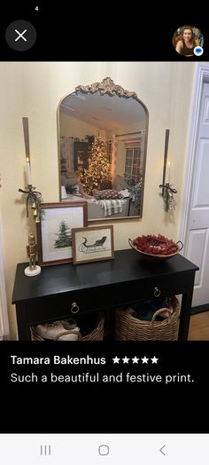 a black table with pictures on it in front of a mirror and christmas tree behind it