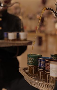 tea being poured into cups on a tray