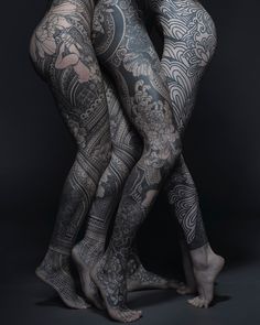 two people with tattoos on their legs and arms