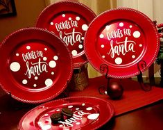 red plates with white polka dots and words on them are sitting on a wooden table