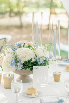 a centerpiece with blue and white flowers on a table