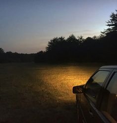 a car parked in the middle of a field at night