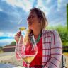 a woman sitting at a table with a glass of wine