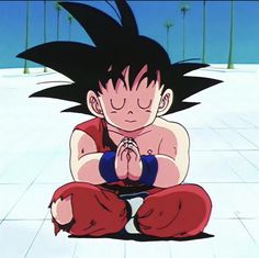 a young gohan sitting on the ground with his hands clasped in front of him