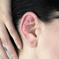 a woman's ear with small stars on it