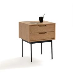 a small wooden table with two drawers and a cup on the top, in front of it