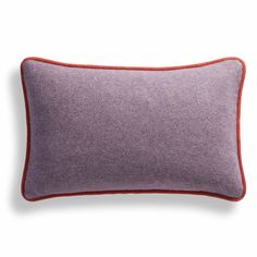 a purple and red pillow with an orange border on the bottom, in front of a white background