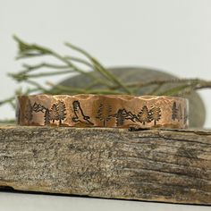 A rustic handmade bracelet that celebrates the beauty of nature and the majesty of the forest with the eagles, mountains and trees hand stamped around the rustic copper cuff. Perfect for the nature lover or hiker in your life. This engraved copper bracelet is hand forged and finished with a hammered finish to give it a rustic look, perfect for men and women alike. Each bracelet is handmade, and no two will be exactly alike. Also please be aware that colors may vary due to viewing screens. If you Rustic Stamped Cuff Bracelet Gift, Rustic Stamped Bracelets For Gifts, Rustic Stamped Bracelets For Gift, Rustic Copper Bracelets As Gift, 22nd Wedding Anniversary, Mountains And Trees, Elder Futhark Runes, Futhark Runes, Copper Cuff Bracelet