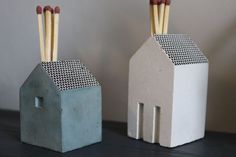 two ceramic houses with sticks sticking out of them