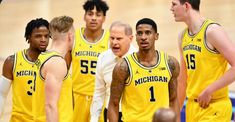 the michigan men's basketball team is talking to each other in a huddle