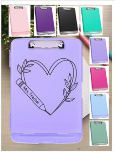 a clipboard with a heart drawn on it and several colors to choose from in the background