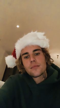 a man wearing a santa hat sitting on top of a couch