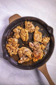 chicken is cooking in a skillet on the stove top, ready to be cooked