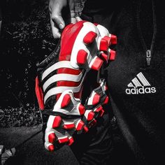 a person holding a soccer glove with red and white stripes