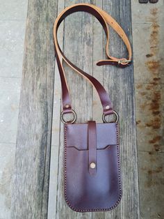 a brown leather bag sitting on top of a wooden bench