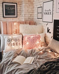 a bed that has some pillows on top of it and lights in front of the headboard