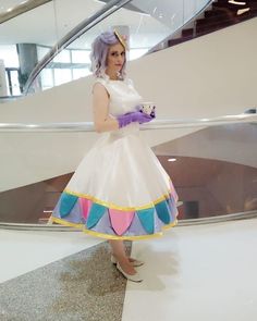 a woman in a white dress and purple gloves is holding a coffee cup while standing next to a staircase