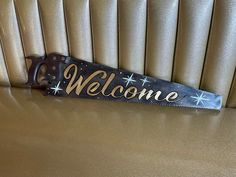 a welcome sign is hanging on the back of a couch in a room with gold walls