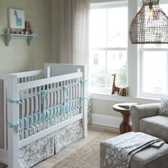 a baby's room with a crib, rocking chair and window in the background