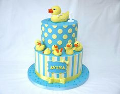 a blue and white cake with rubber ducks on it