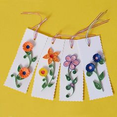 paper flowers hanging from clothes pins on a yellow background