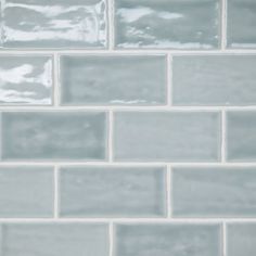 a close up view of a white tile wall with gray grouting on it