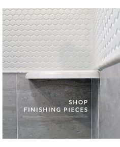 a sign that says shop finishing pieces on the side of a bathtub with hexagonal tiles