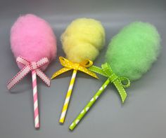 three different colored lollipops with bows on them