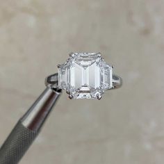 a close up of a diamond ring being held by a person's hand with a screwdriver