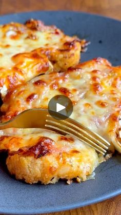 a piece of pizza is being cut with a fork and knife on a blue plate