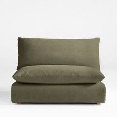 an olive green couch with two pillows on the back and one pillow folded over it