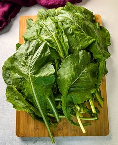 some green leafy vegetables are on a cutting board